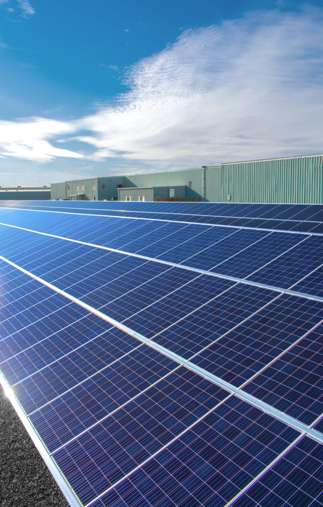 Western Woods Solar Array beauty shot with warehouse. An example of our commitment to sustainability.